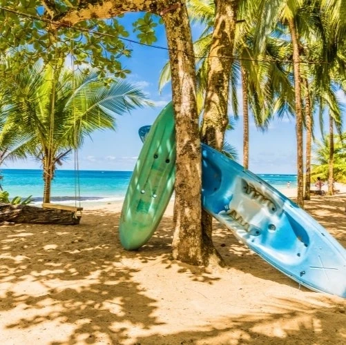 Deux kayaks posés sur le sable entre deux arbres à Punta Uva au Costa Rica